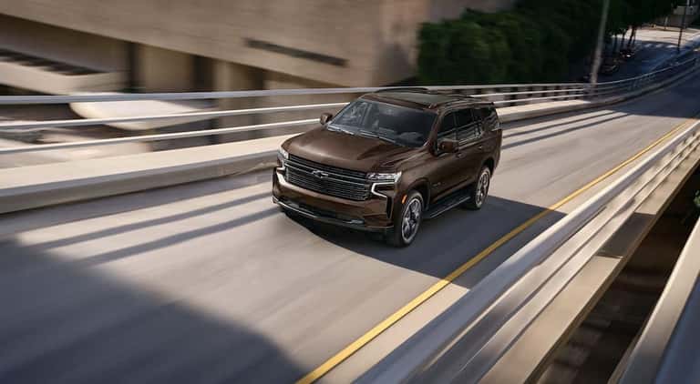 A brown 2024 Chevy Tahoe RST is shown from the front at an angle.