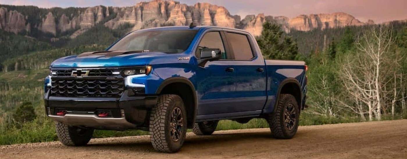A blue 2024 Chevy Silverado 1500 ZR2 is shown parked near a mountain.