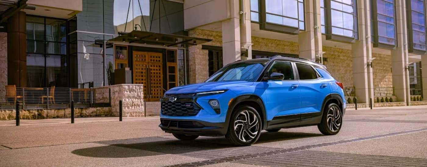 A blue 2024 Chevy Trailblazer RS is shown parked near a building.