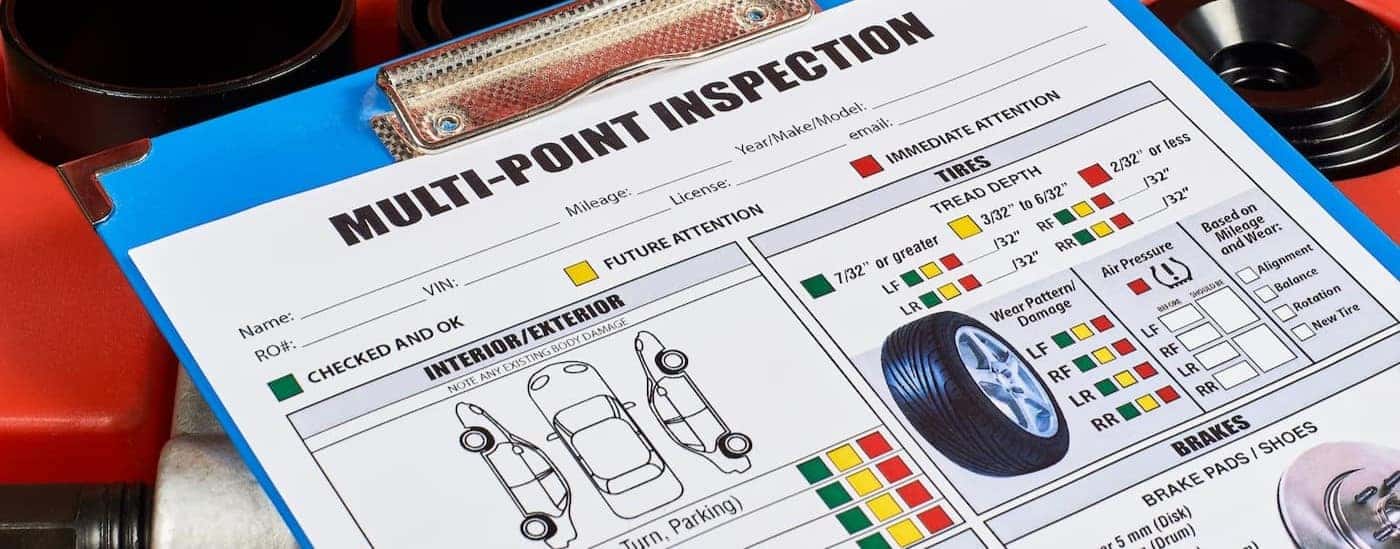 A multi-point inspection sheet is shown on a clipboard.