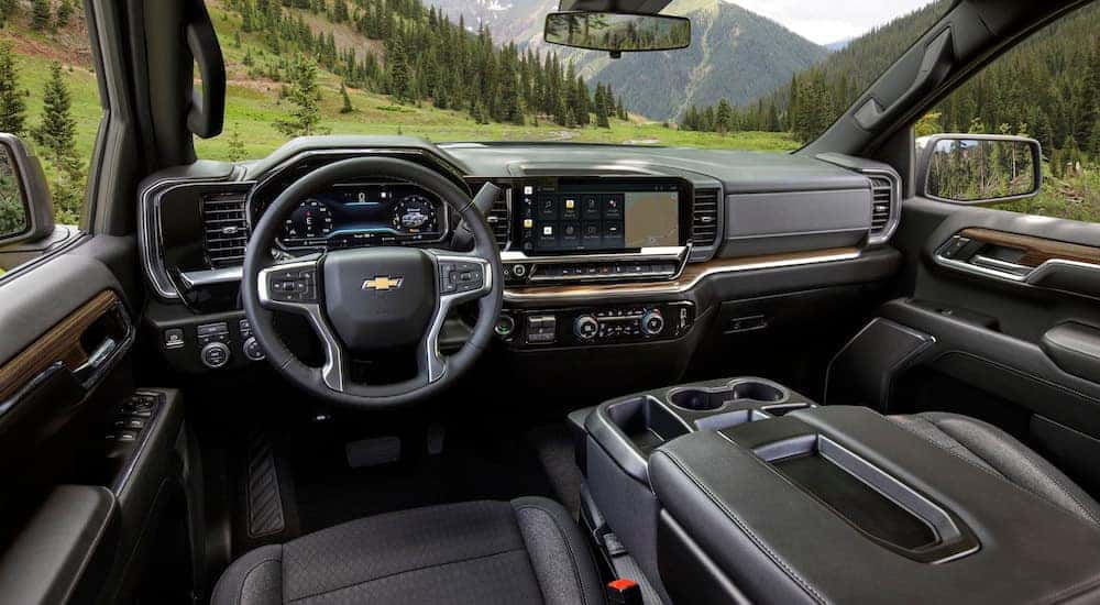 The black interior of a 2024 Chevy Silverado 1500 LT is shown from the driver's seat.