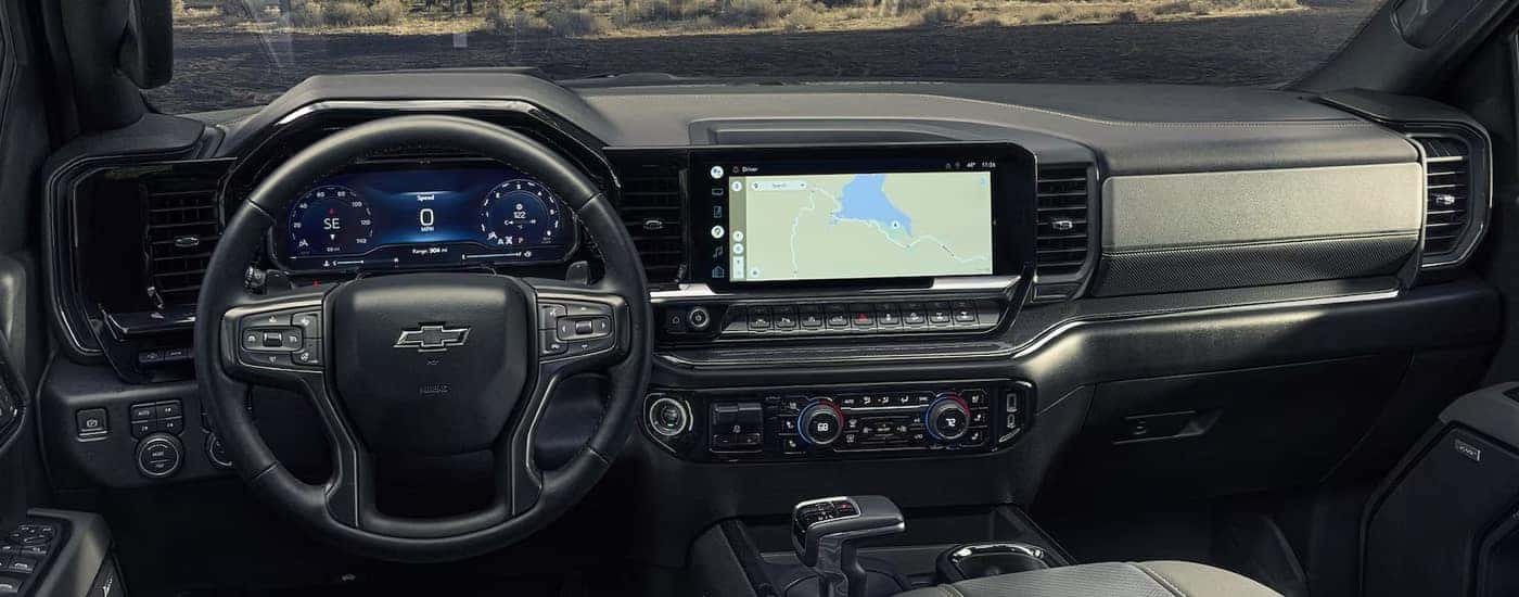 The steering wheel and dashboard in a 2024 Chevy Silverado 1500 for sale.