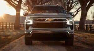 Head-on view of a silver 2024 Chevy Silverado 1500 LT Z71 driving on a country lane.