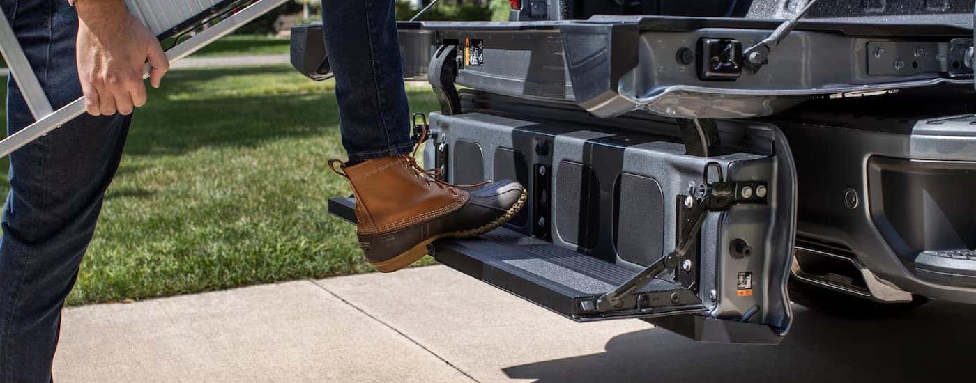 The MultiFlex tailgate on a black 2024 Chevy Silverado 1500 being used as a step.
