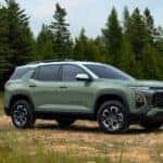 A sage green 2025 Chevy Equinox ACTIV parked in a field.