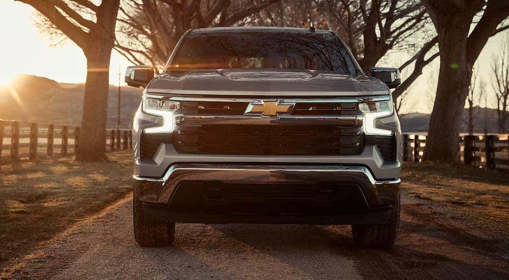 Head-on view of a silver 2024 Chevy Silverado 1500 LT Z71 driving on a farm.