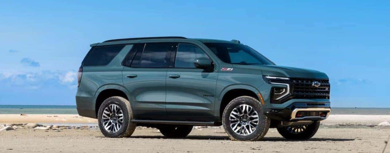 A green 2025 Chevy Tahoe Z71 is shown parked on a beach.