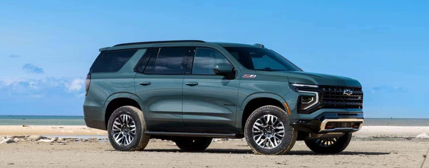 A green 2025 Chevy Tahoe Z71 is shown parked on a beach.