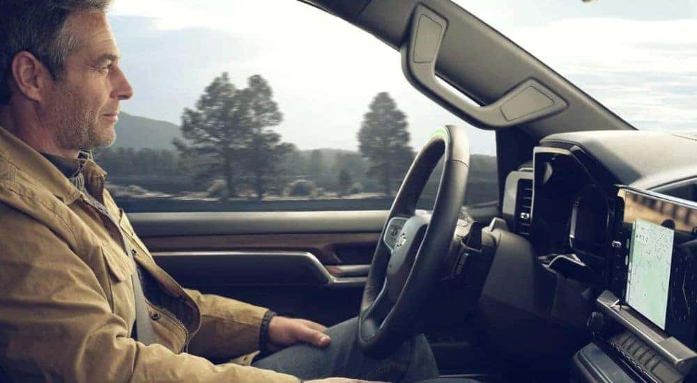 A person is shown using the Super Cruise feature in a Chevy Silverado 1500 for sale near Sandy Springs.