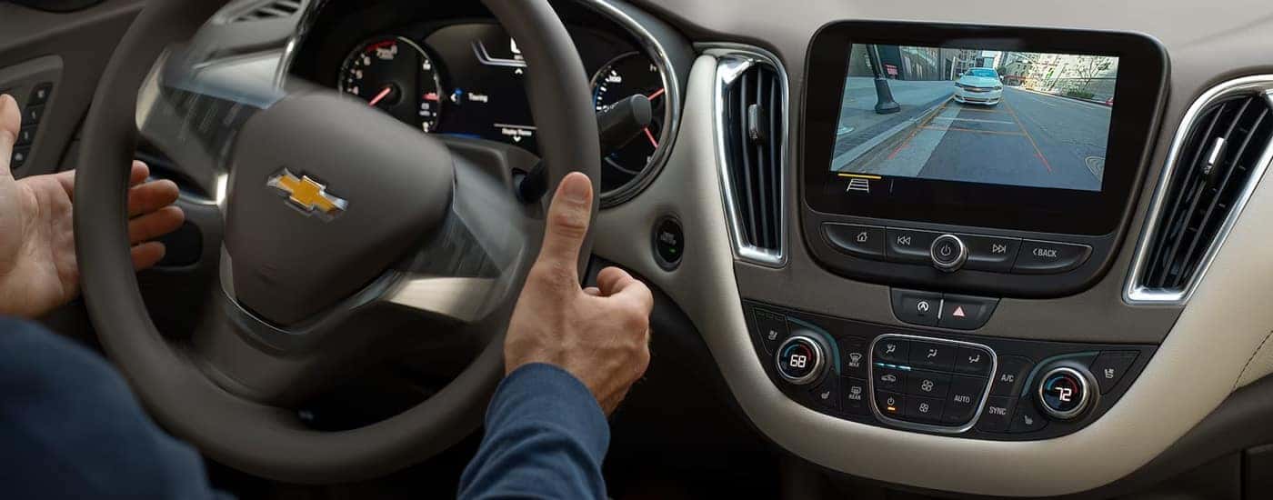 The driver of a 2025 Chevy Malibu RS using the Park Assist feature.