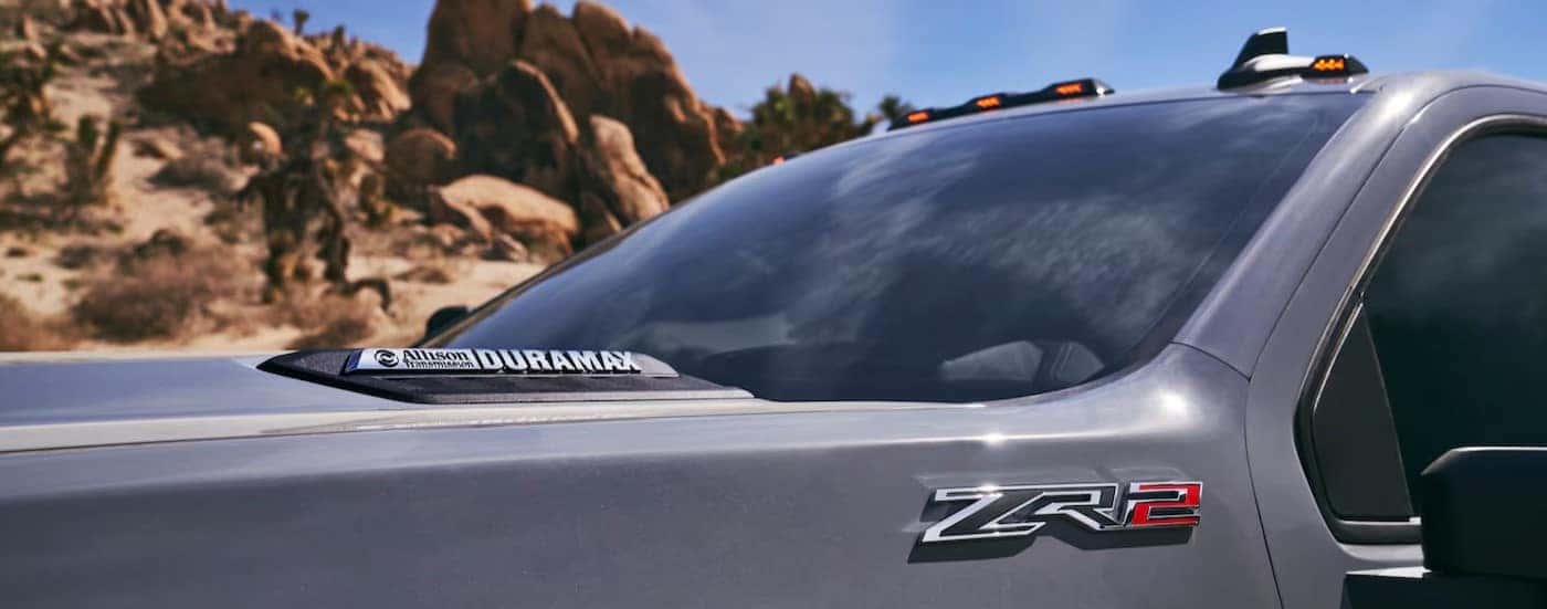 A close-up of the ZR2 badge in a gray 2025 Chevy Silverado 2500 ZR2 is shown.