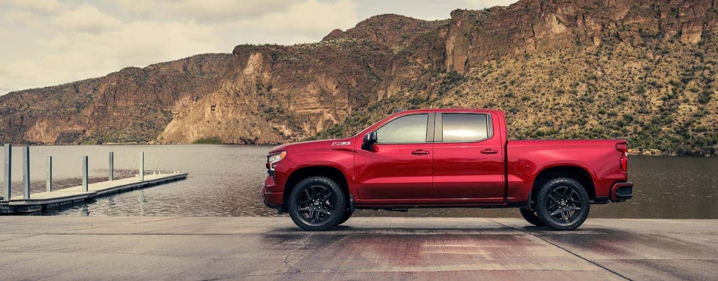 A red 2025 Chevy Silverado 1500 Z71 is shown parked near a lake.