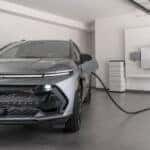 A grey 2025 Chevy Equinox EV parked in a garage and charging.