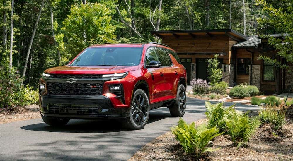 A red 2025 Chevy Traverse RS is shown from the front at an angle.