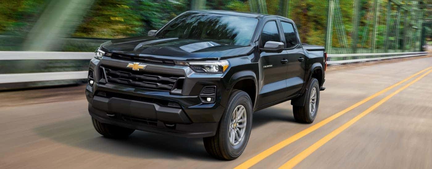 A black 2025 Chevy Colorado driving across a bridge.