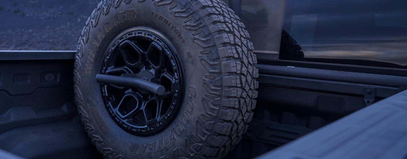 A wheel in the bed of a white 2025 Chevy Colorado ZR2 Bison.