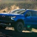 Blue 2025 Chevy Silverado 1500 ZR2 for sale in Atlanta driving up a dirt hill.