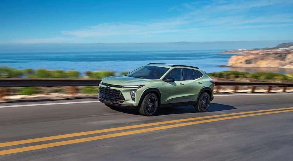 A green 2025 Chevy Trax ACTIV driving on a highway.