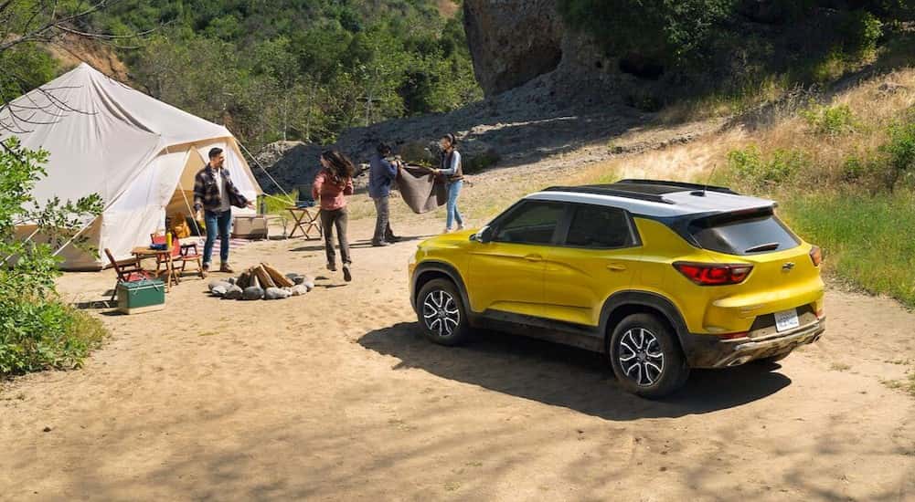 A yellow 2025 Chevy Trailblazer ACTIV parked on a campsite.