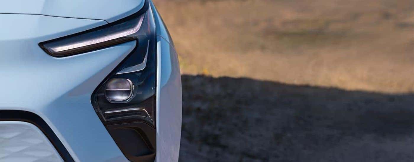 Close-up on the headlight of a light blue 2022 Chevy Bolt EV parked after leaving a Chevrolet dealer near Atlanta, GA.