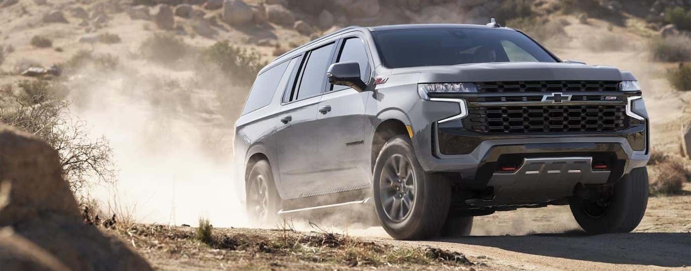 Grey 2024 Chevy Suburban Z71 driving off-road after leaving a used Chevy dealer in Chamblee, GA.