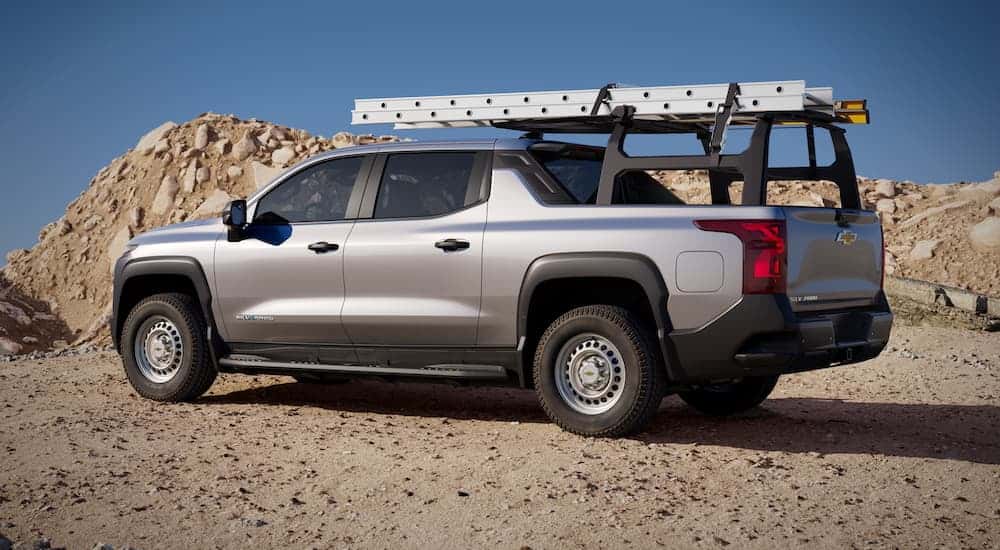 A silver 2025 Chevy Silverado EV from the side while parked off-road.
