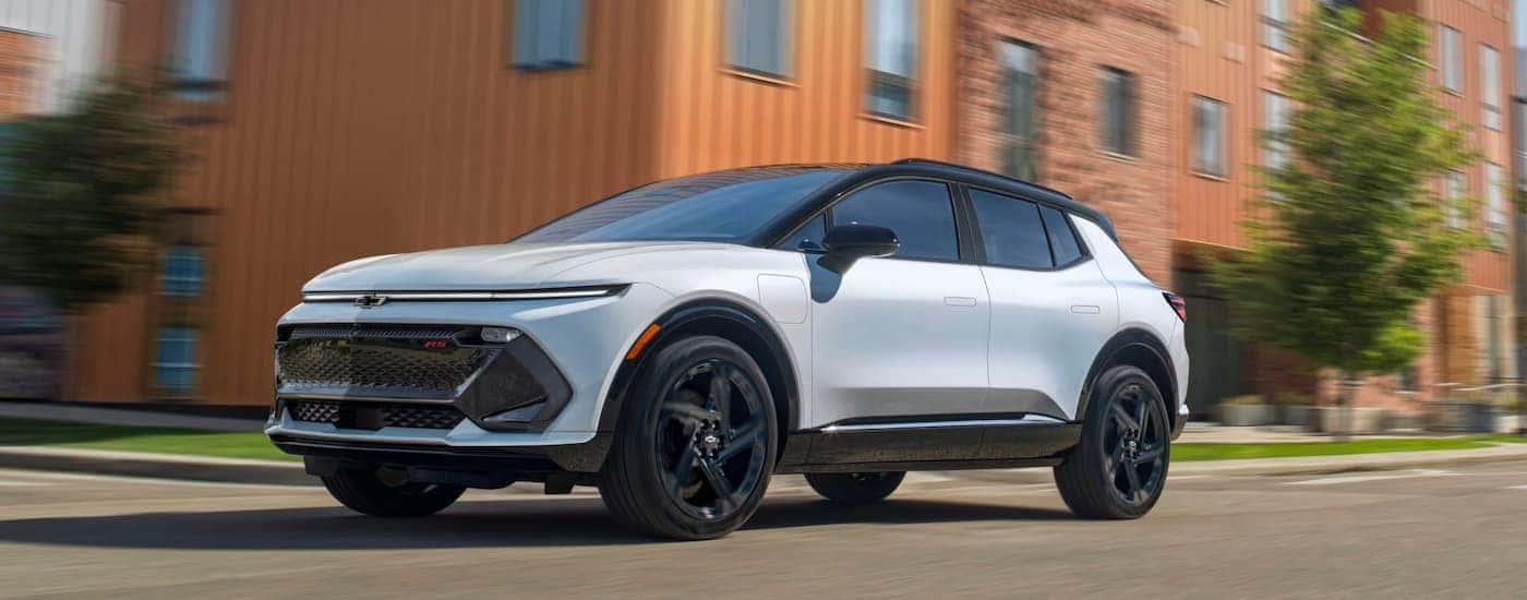 White 2025 Chevy Equinox EV driving down a bridge.