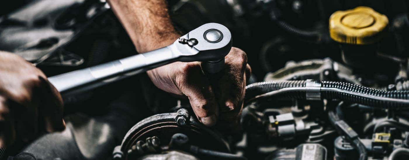 Mechanic performing auto service near Sandy Springs on an engine.