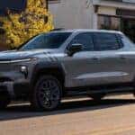 A gray 2025 Chevy Silverado EV for sale parked in a city