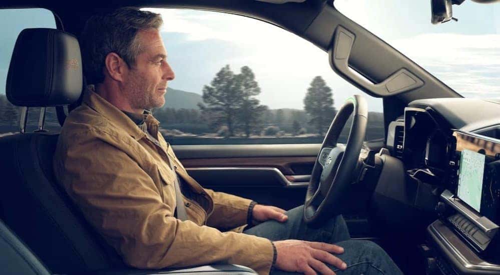 A person driving in a 2026 Chevy Silverado 1500.