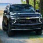 A blue 2025 Chevy Tahoe driving off-road.