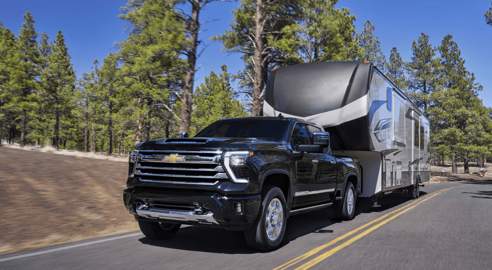 Black 2026 Chevy Silverado 2500 HD towing a camper