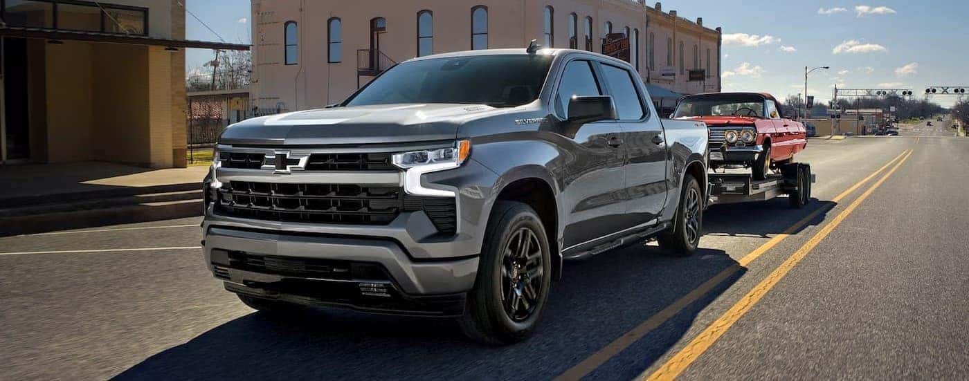 A silver 2026 Chevy Silverado 1500 towing a trailer.