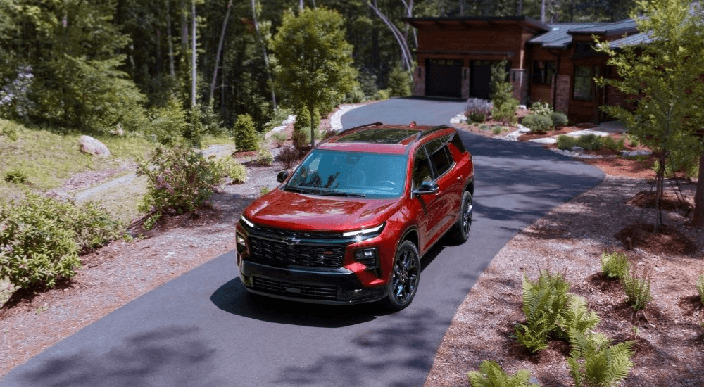 Red 2026 Chevy Traverse RS drives down a driveway