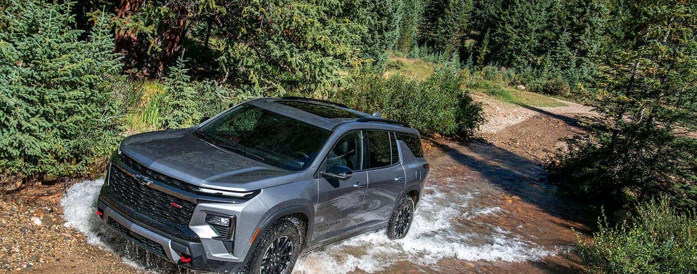 A gray 2026 Chevy Traverse Z71 driving through water