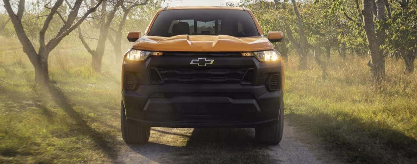 A yellow 2026 Chevy Colorado driving on a dirt trail.