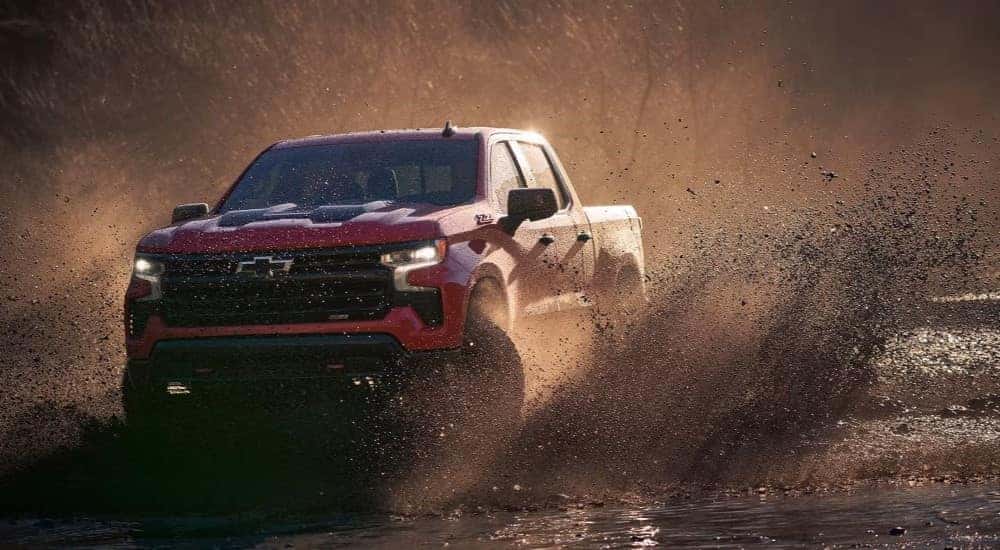 A red 2023 Chevy Silverado 1500 off-roading for sale near Johns Creek