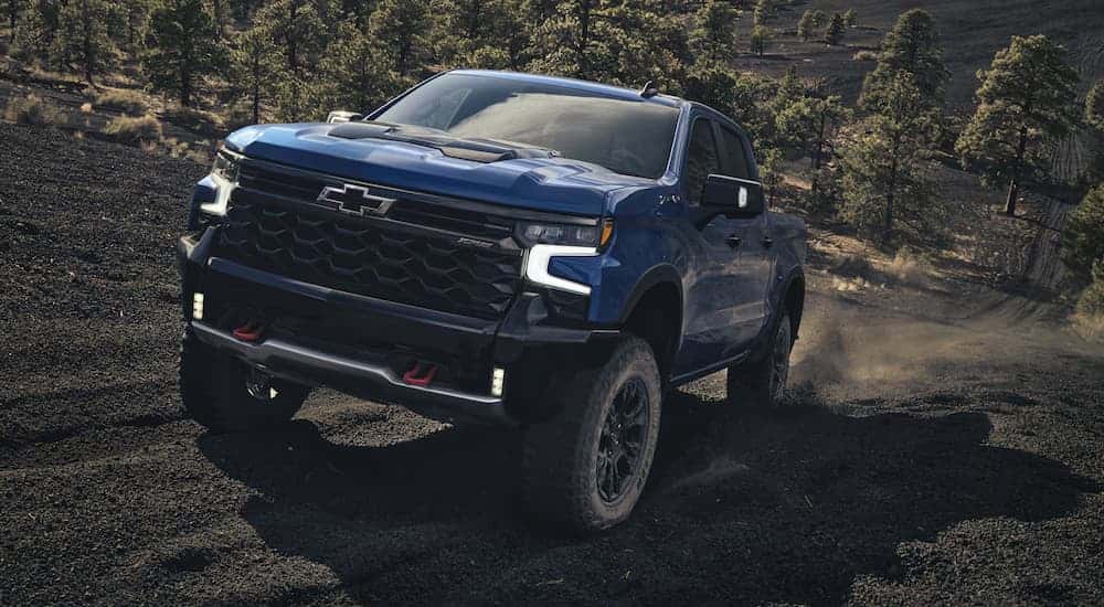 A blue 2026 Chevy Silverado 1500 ZR2 off-roading on a dirt hill
