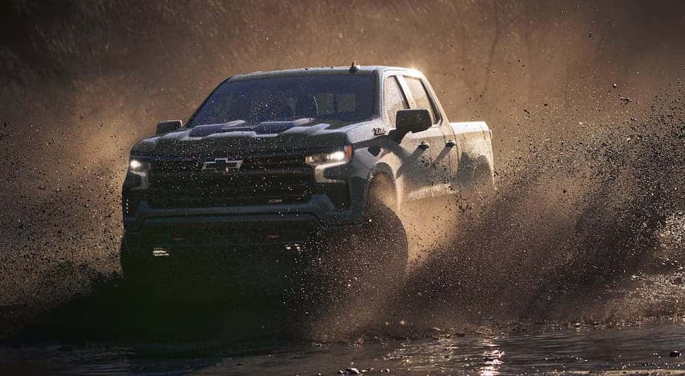 A blue 2026 Chevy Silverado 1500 ZR2 for sale near Johns Creek off-roading in mud