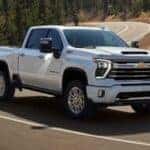 A white 2026 Chevy Silverado 2500 HD driving down a road