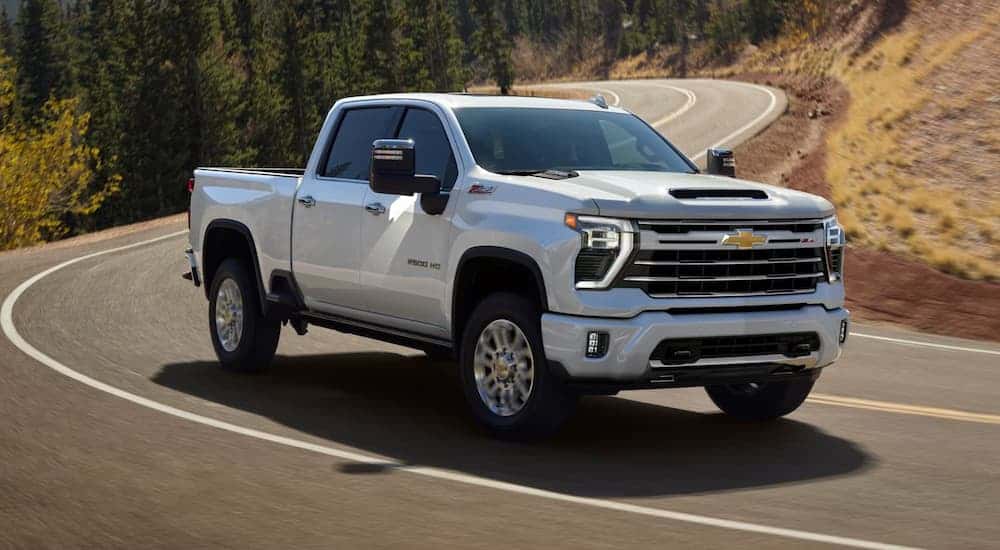 A white 2026 Chevy Silverado 2500 HD driving down a road