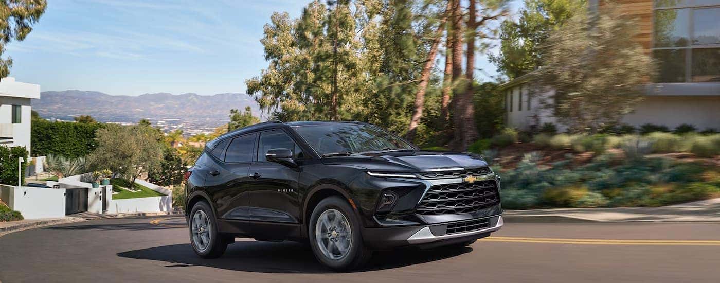 A black 2026 Chevy Blazer driving in a residential area