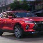 A red 2026 Chevy Blazer driving in a city.