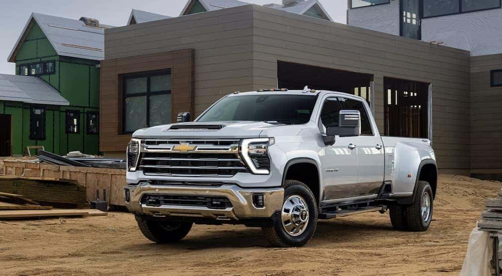 White 2025 Chevy Silverado 1500 parked off-road by a construction site.