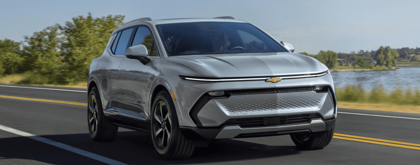 Silver 2026 Chevy Equinox EV driving down an open road