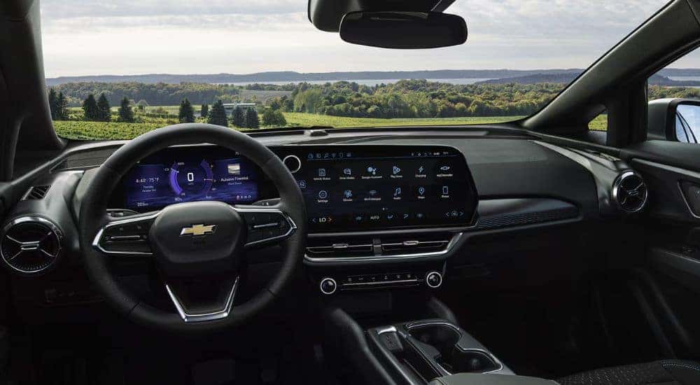 2026 Chevy Equinox EV front dashboard parked in front of greenery