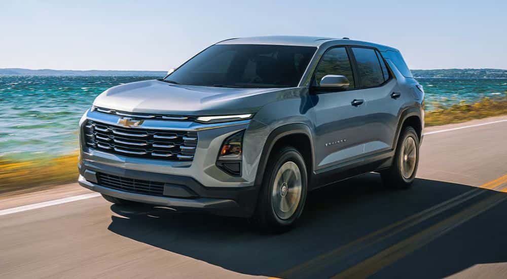 Grey 2026 Chevy Equinox driving down the road along the water