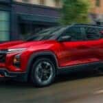 Red 2026 Chevy Equinox driving down a city street