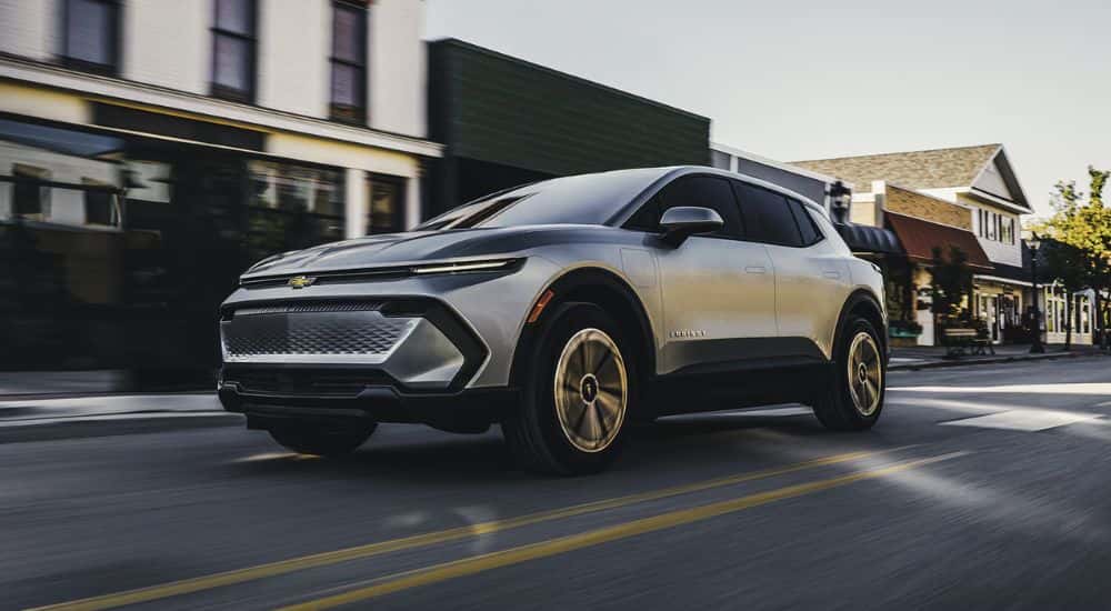 Silver 2026 Chevy Equinox EV driving down a street