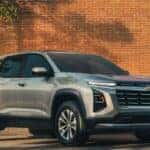 A silver 2026 Chevy Equinox parked in front of a brick wall.